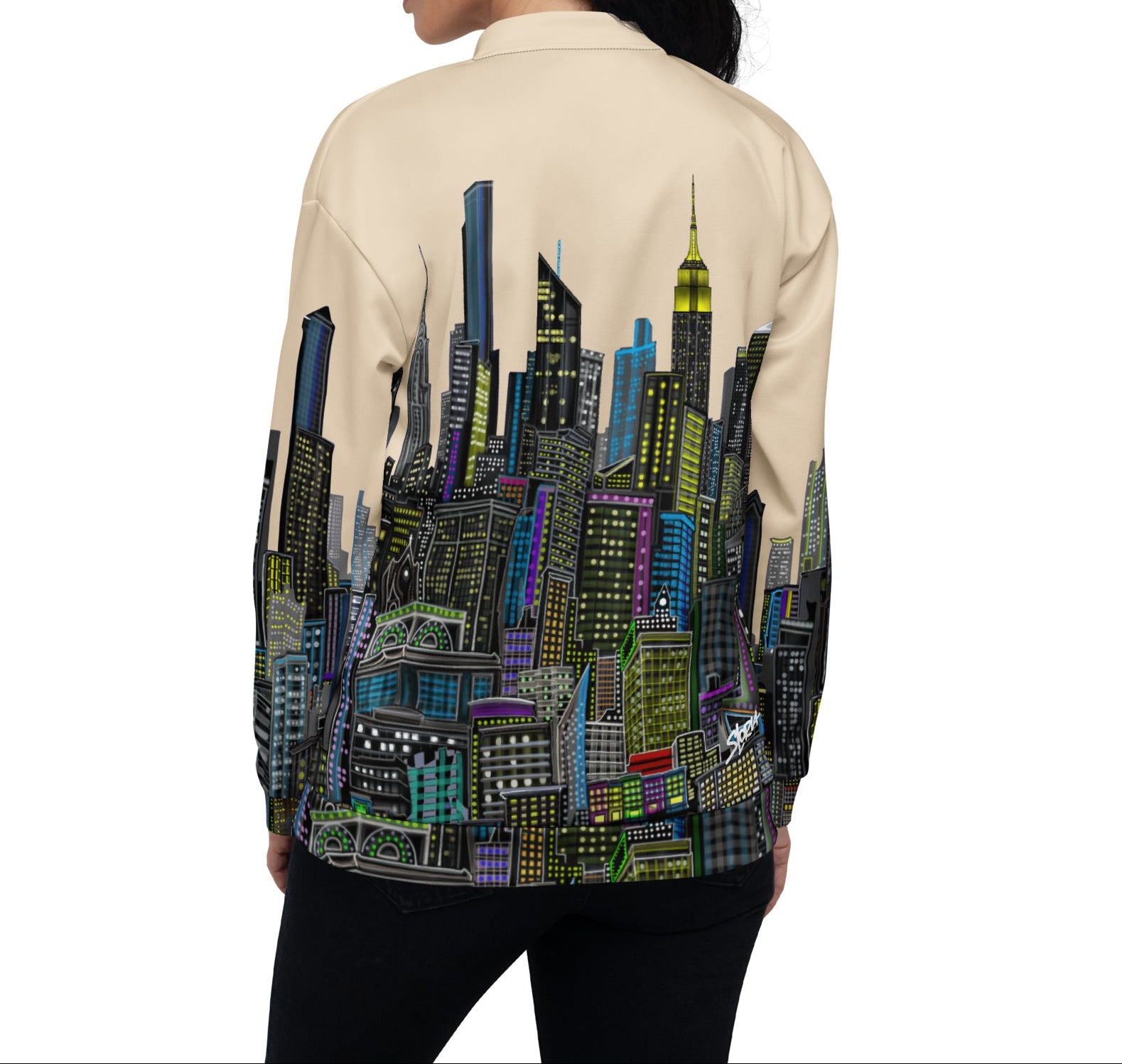 View of Person wearing a beige shirt with a colorful cityscape Loria NYC Art design on the back