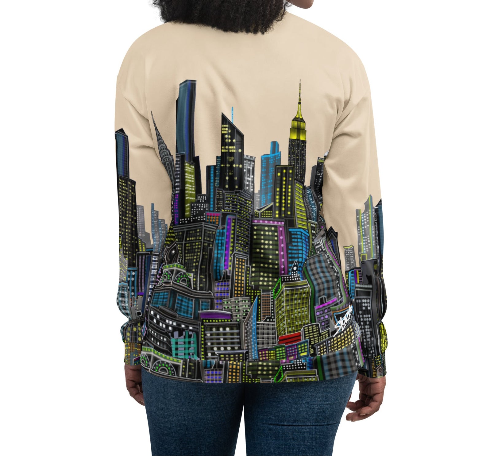Woman wearing a beige jacket with a colorful Loria NYC Art cityscape design on the back.