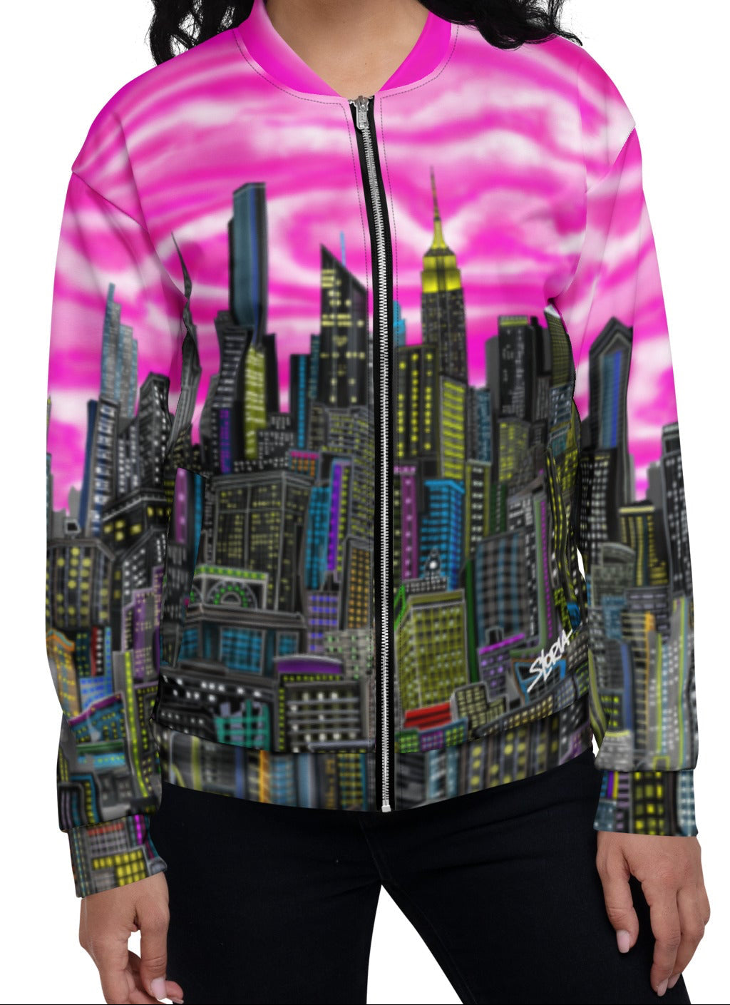 Woman wearing a colorful cityscape jacket with pink sky and tall buildings designed by Loria NYC Art