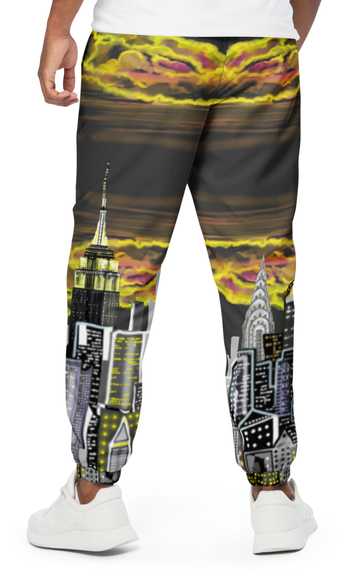 Person wearing a white t-shirt and colorful pants with a Loria NYC Art cityscape design on a white background