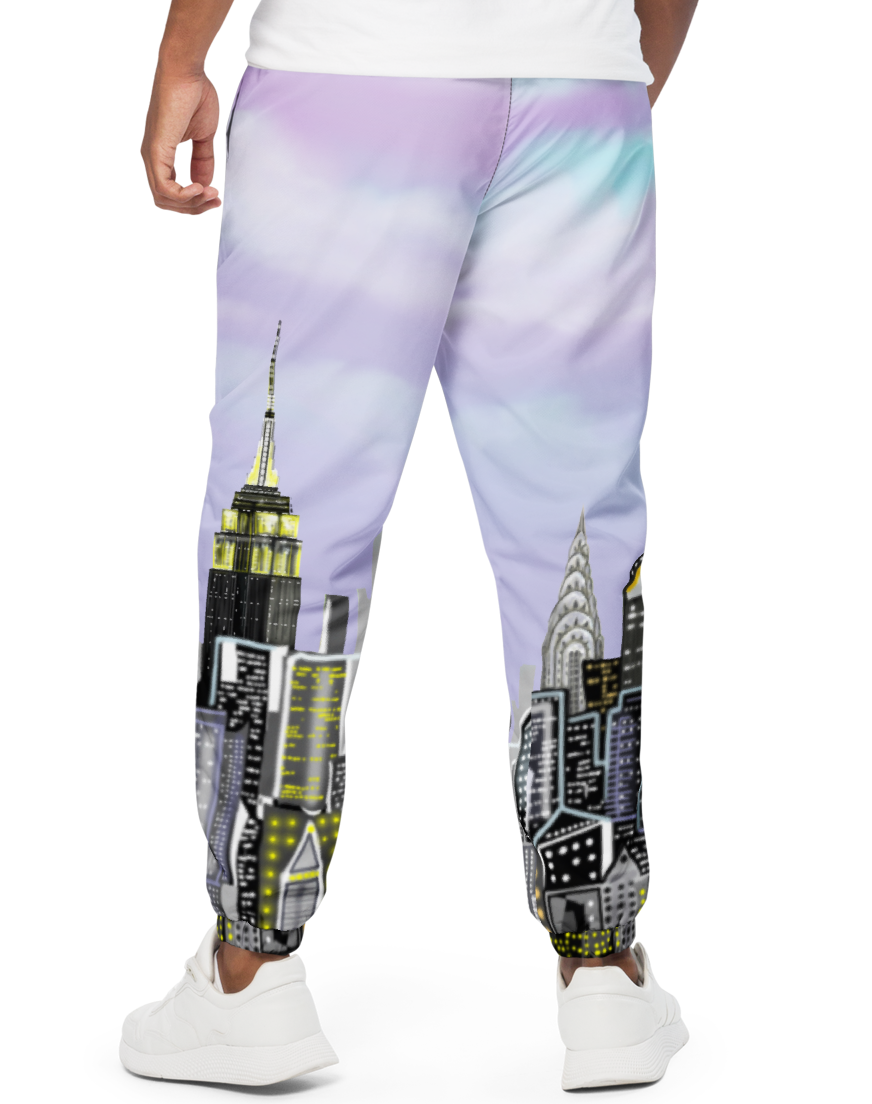 Person wearing a white t-shirt and colorful pants with cityscape Loria NYC Art design on a white background
