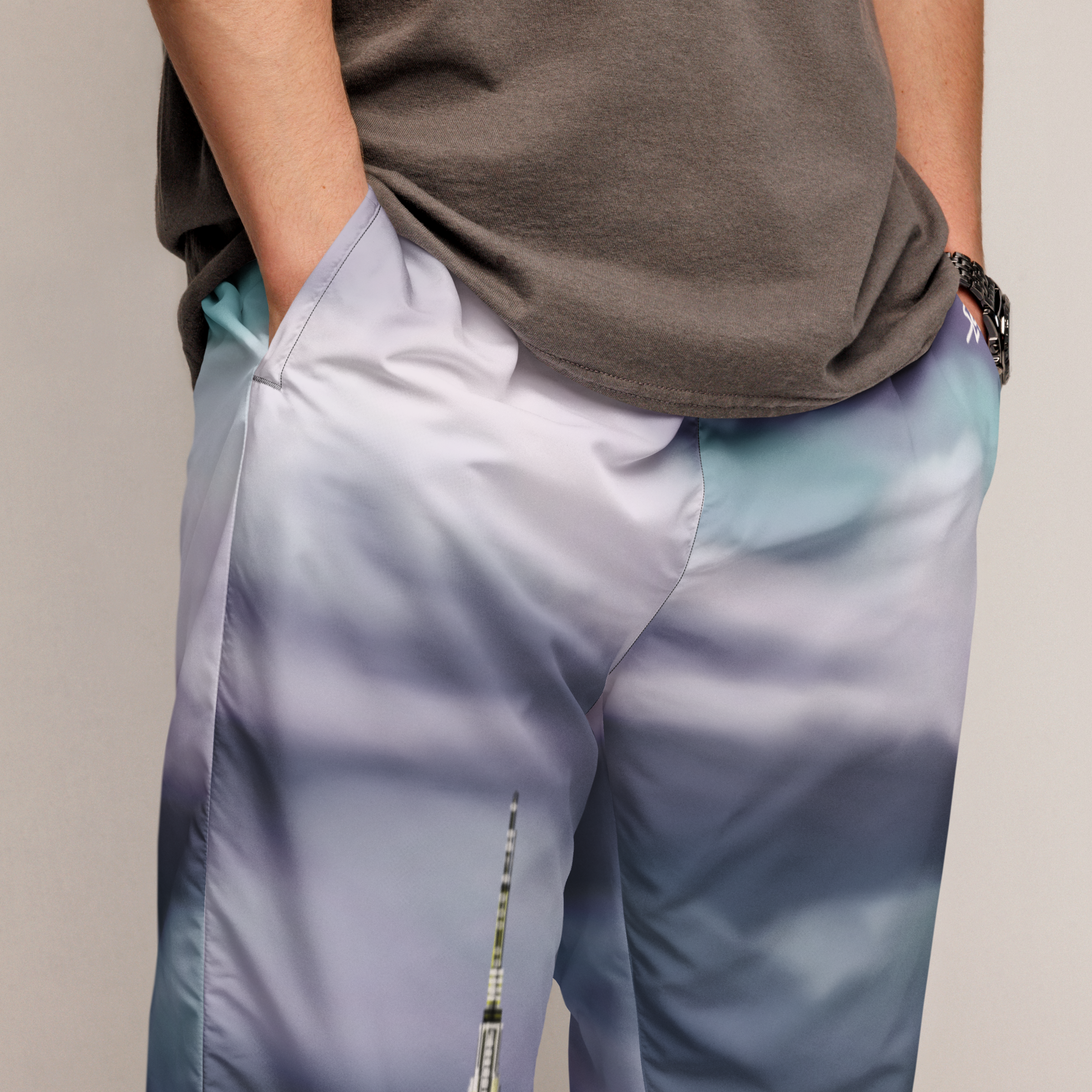 Person wearing a brown shirt and gradient Loria NYC Art pants on a neutral background