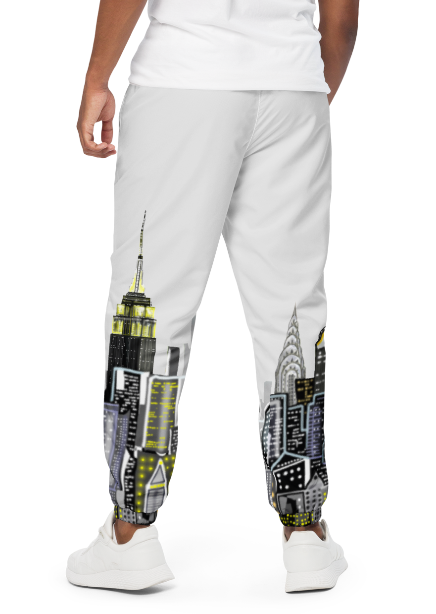 Man wearing a white t-shirt and Loria NYC Art pants with cityscape design on a white background