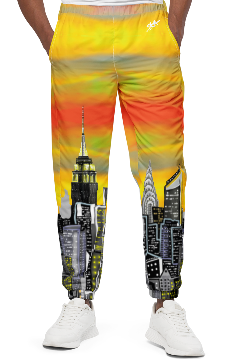 Man wearing a colorful Loria NYC Art sweatshirt with a cityscape design on a white background