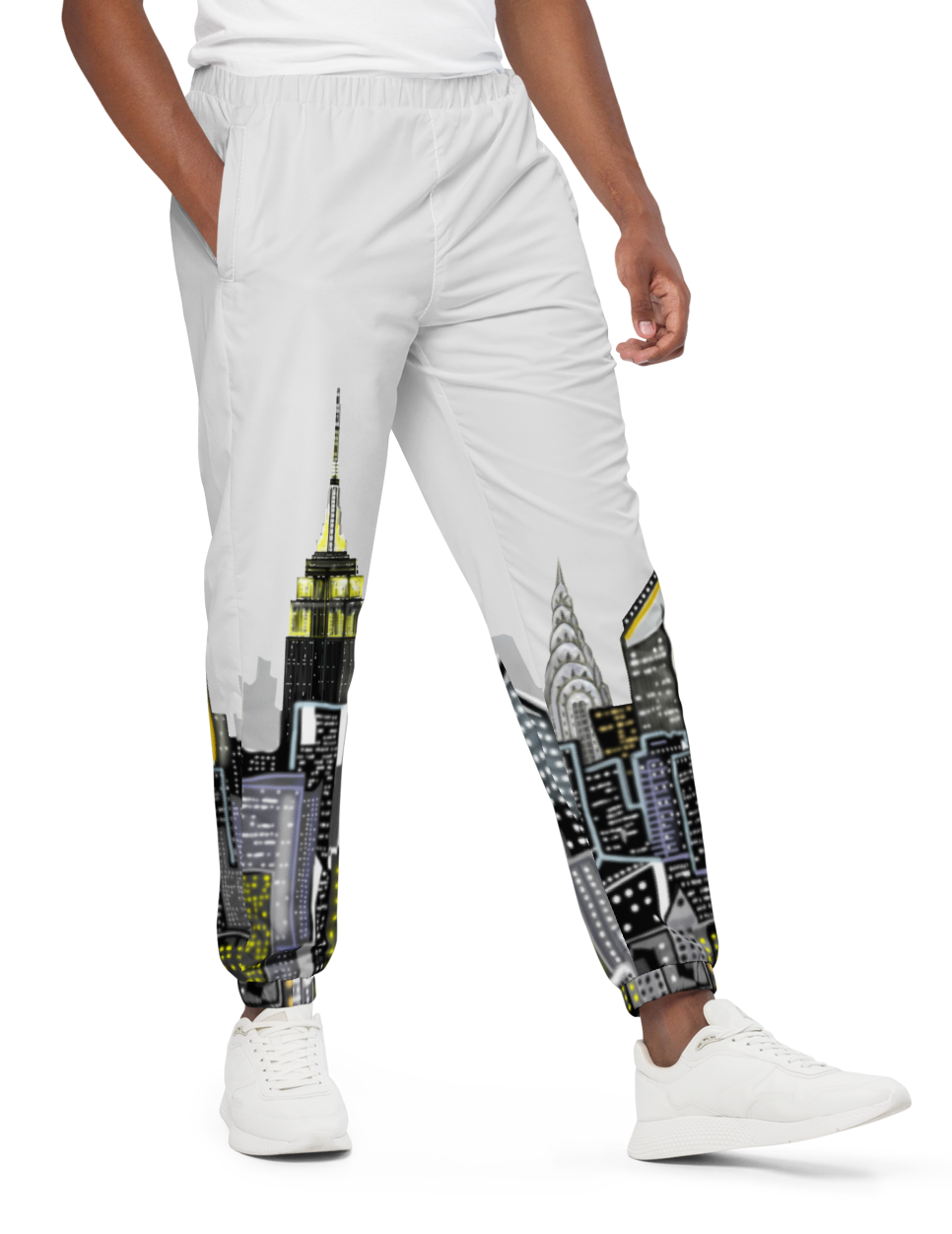Man wearing a white t-shirt and Loria NYC Art pants with cityscape design on a white background