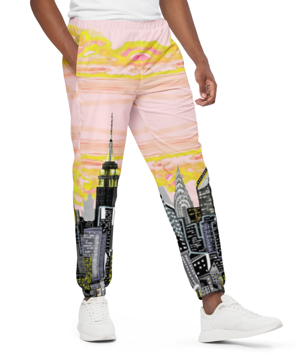 Man wearing a white t-shirt and Loria NYC Art colorful pants with cityscape design on a white background