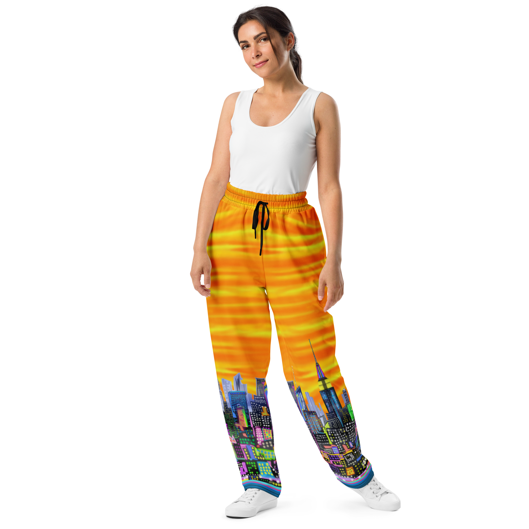 Woman wearing a white tank top and colorful pants with Loria NYC Art cityscape design on a white background