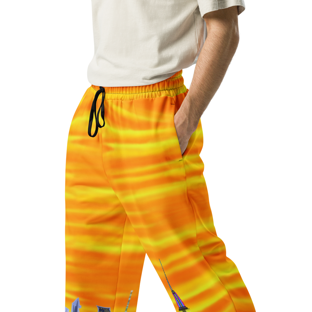 Person wearing bright orange and yellow striped Loria NYC Art pants on a white background