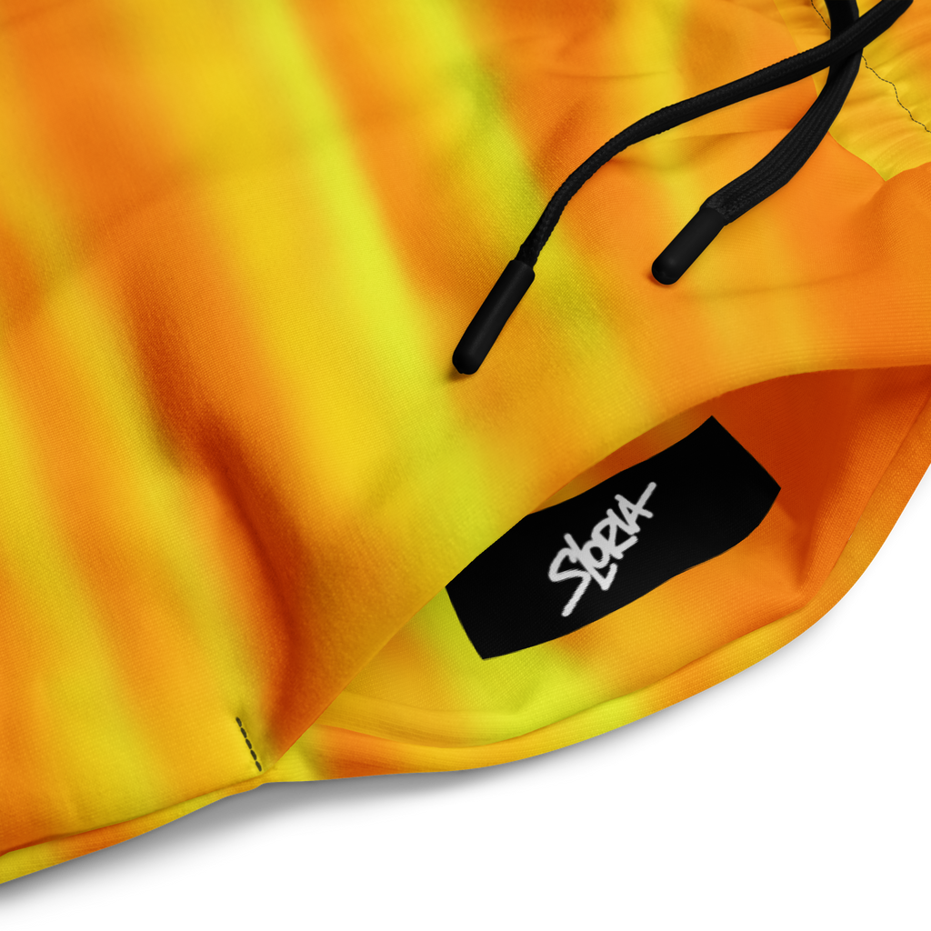Close-up of a yellow and orange Loria NYC Art pants with a black drawstring and visible brand logo.