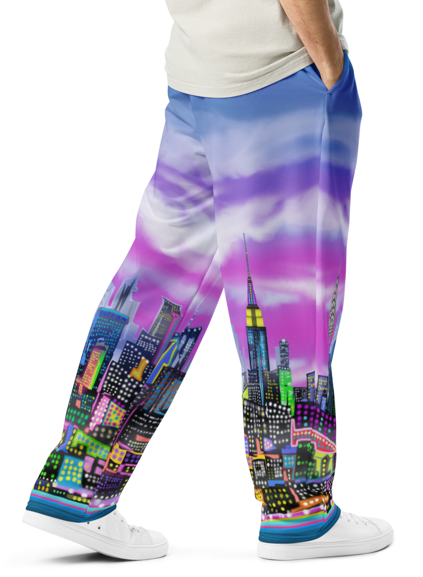 Man wearing colorful Loria NYC Art cityscape pants with a white background