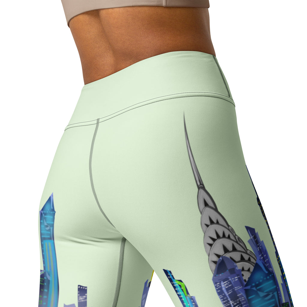 Light green leggings with a Loria NYC Art cityscape design on a white background