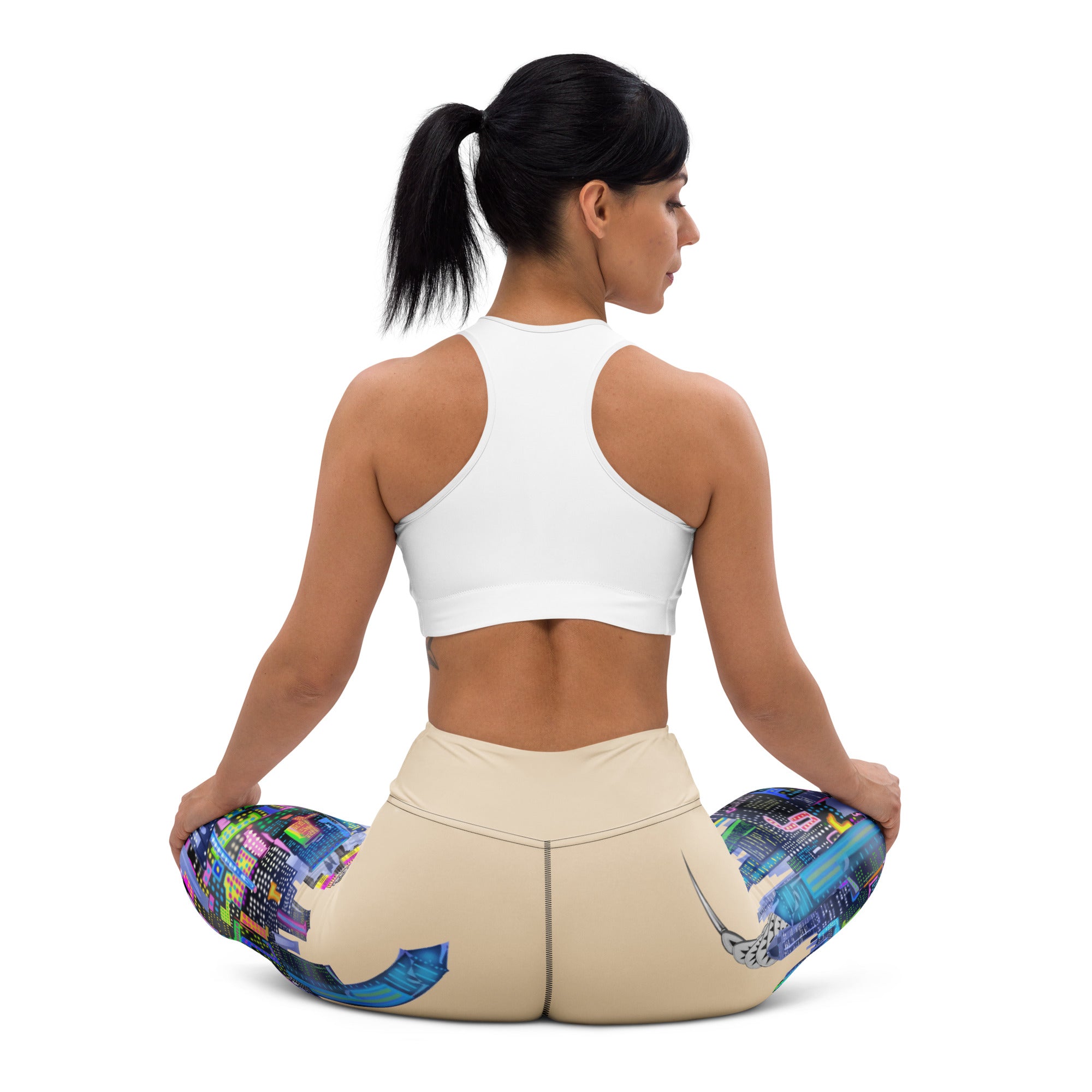Woman wearing Loria NYC Art yoga pants  sitting down on a with a white background
