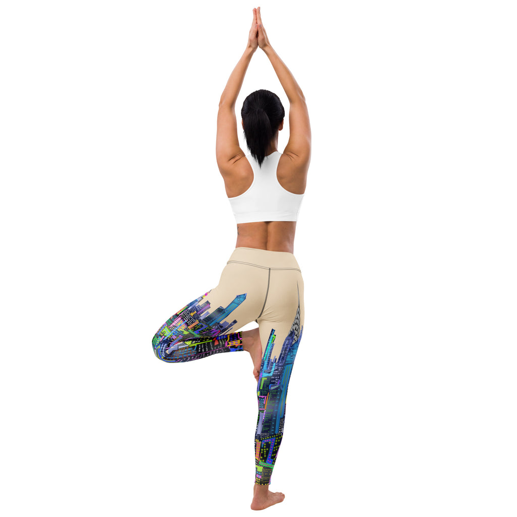 Person wearing colorful Loria NYC Art leggings and a white sports bra, standing on one leg with hands pressed together.