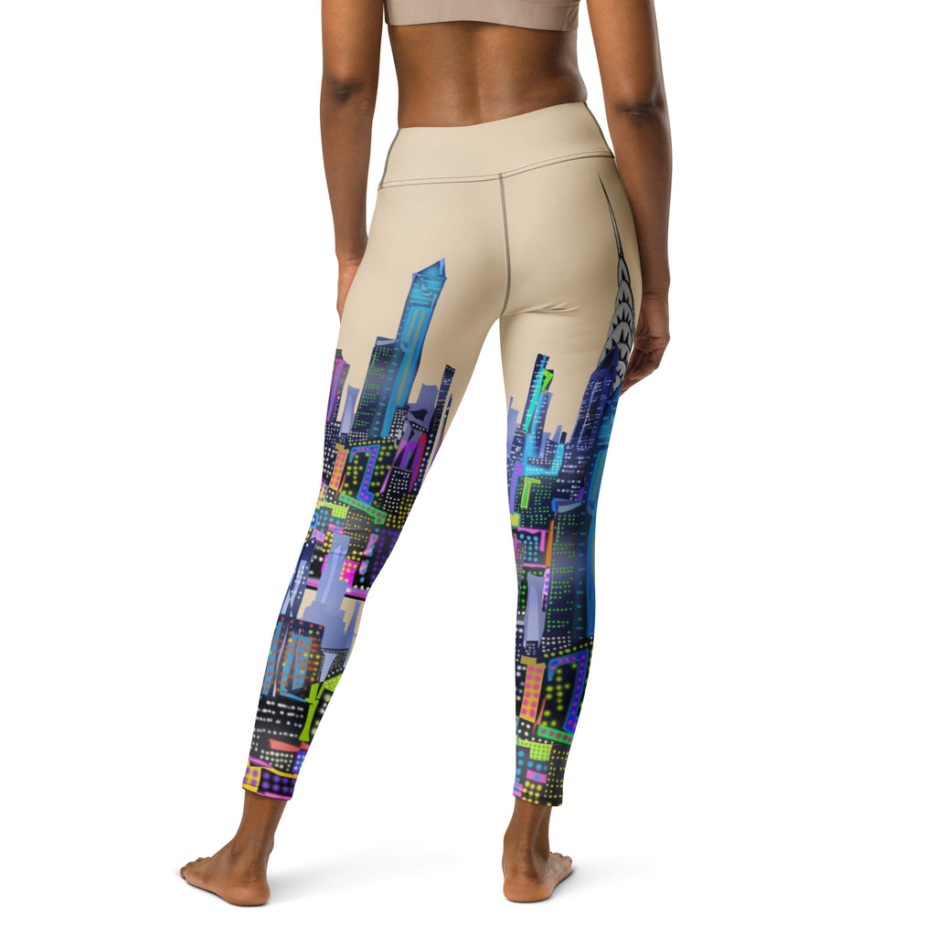 Beige leggings with colorful Loria NYC Art cityscape design worn by a person on a white background