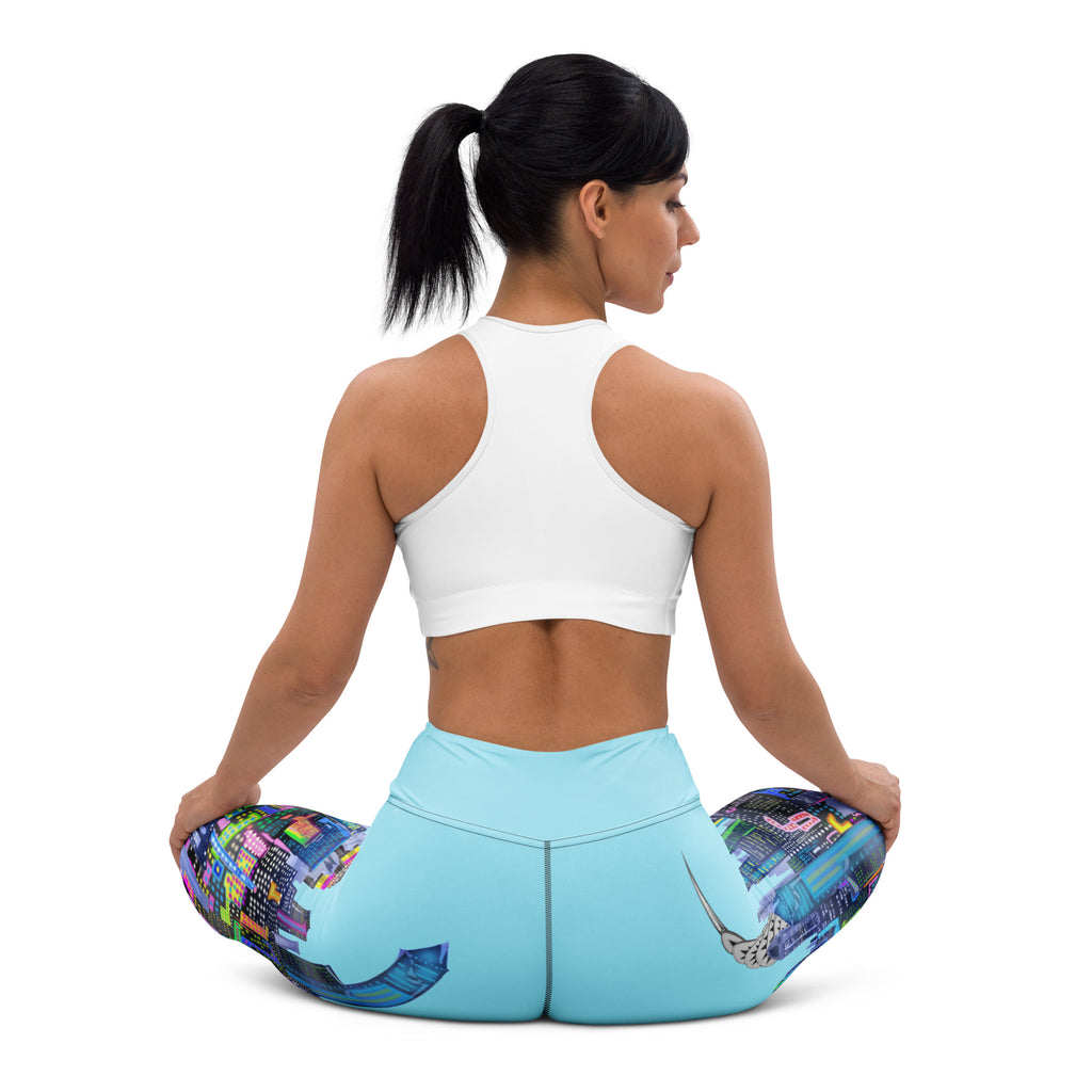 Woman wearing blue Loria NYC Art yoga pants and sits on white background