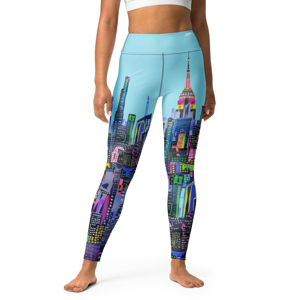 Girl wearing blue Loria NYC Art Leggings with cityscape design worn by a person on a white background