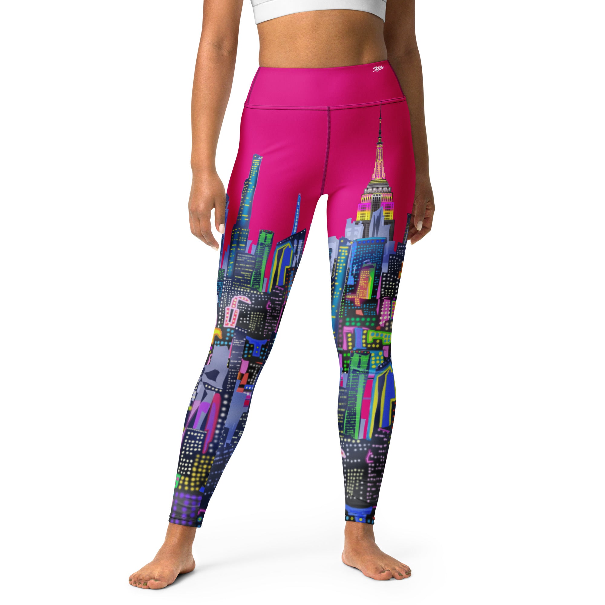 Person wearing pink leggings with a colorful cityscape Loria NYC Art design on a white background