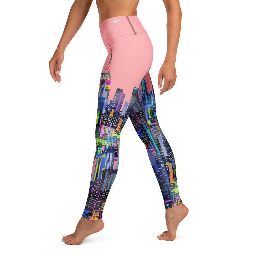 Colorful patterned Loria NYC Art leggings with a pink top on a white background