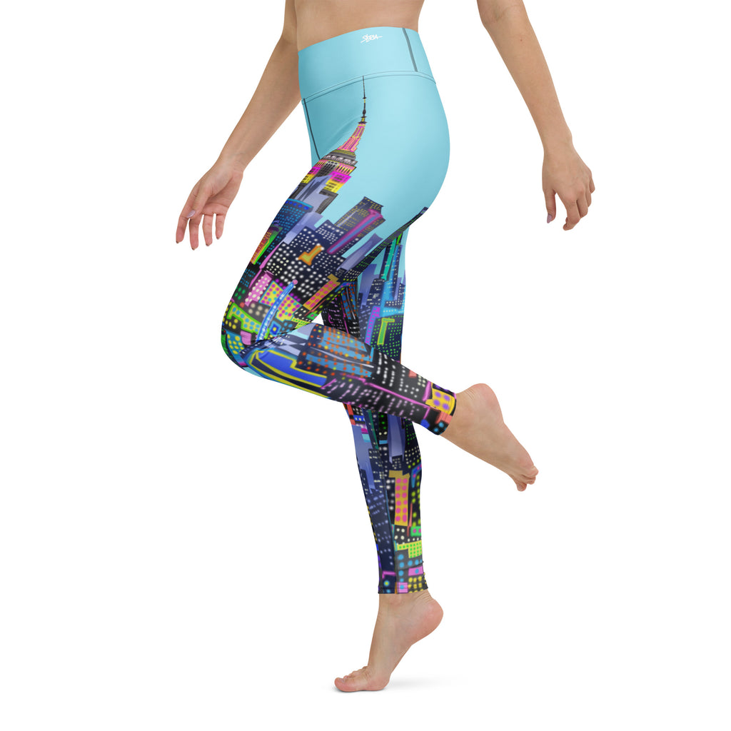 Colorful cityscape Loria NYC Art leggings with a light blue top on a white background