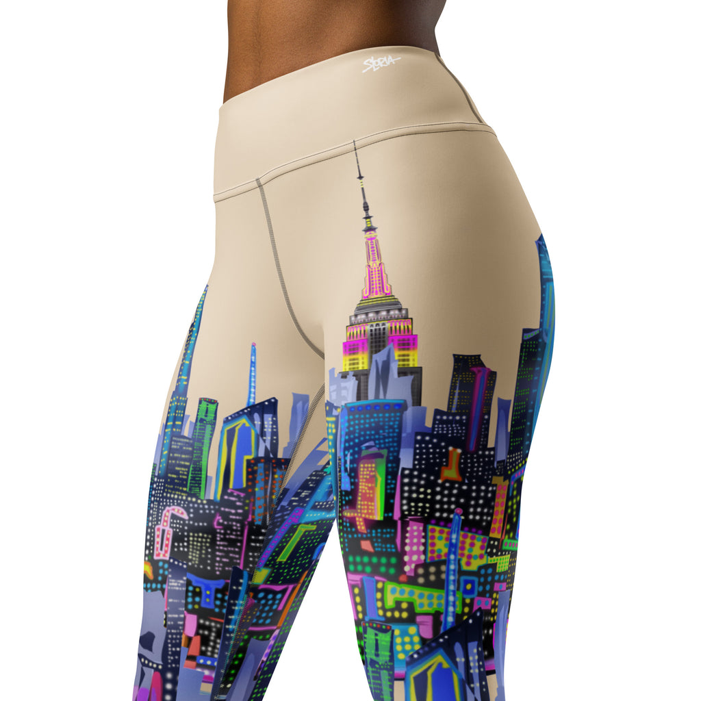 Beige Loria NYC Art leggings with colorful cityscape design on a white background