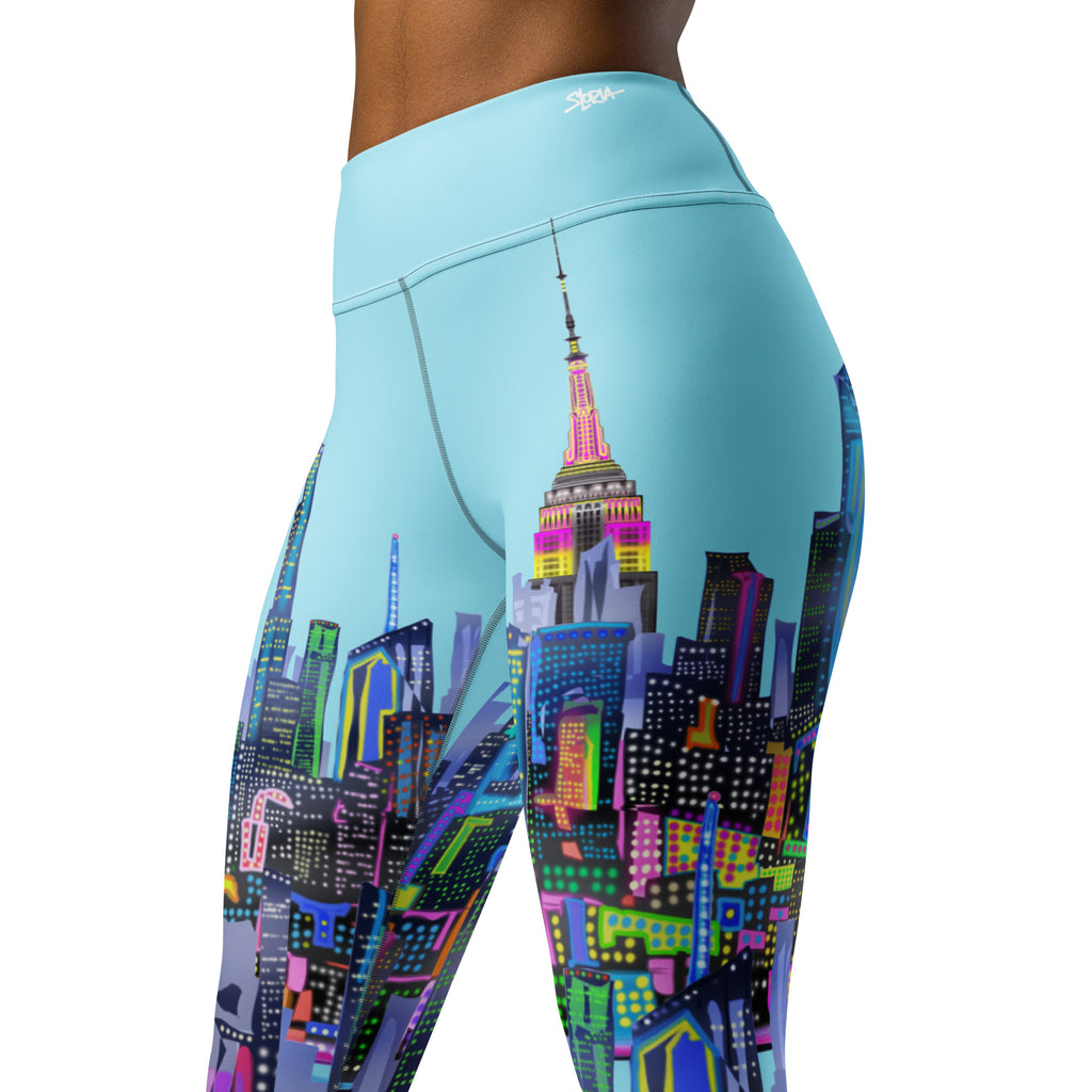 Loria NYC Art Leggings with a colorful cityscape design on a light blue background