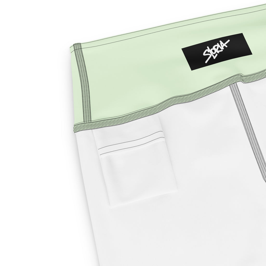 Close-up of a white garment with green trim and a black S.Loria label on a white background