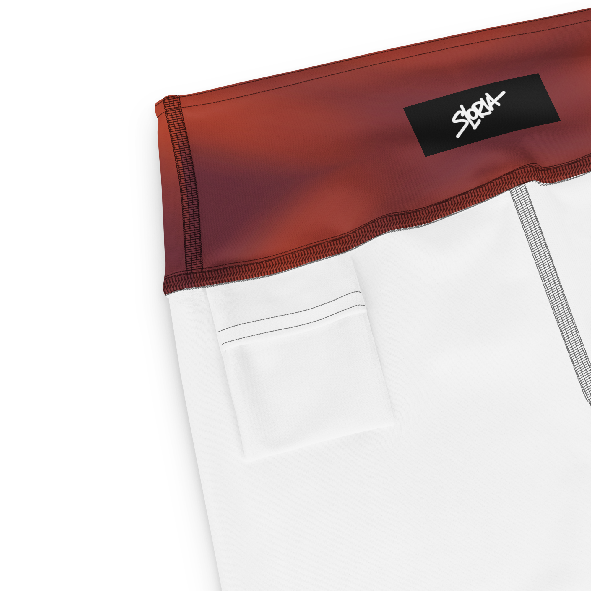 Close-up of a white garment with red trim and a black Loria NYC Art label on a white background