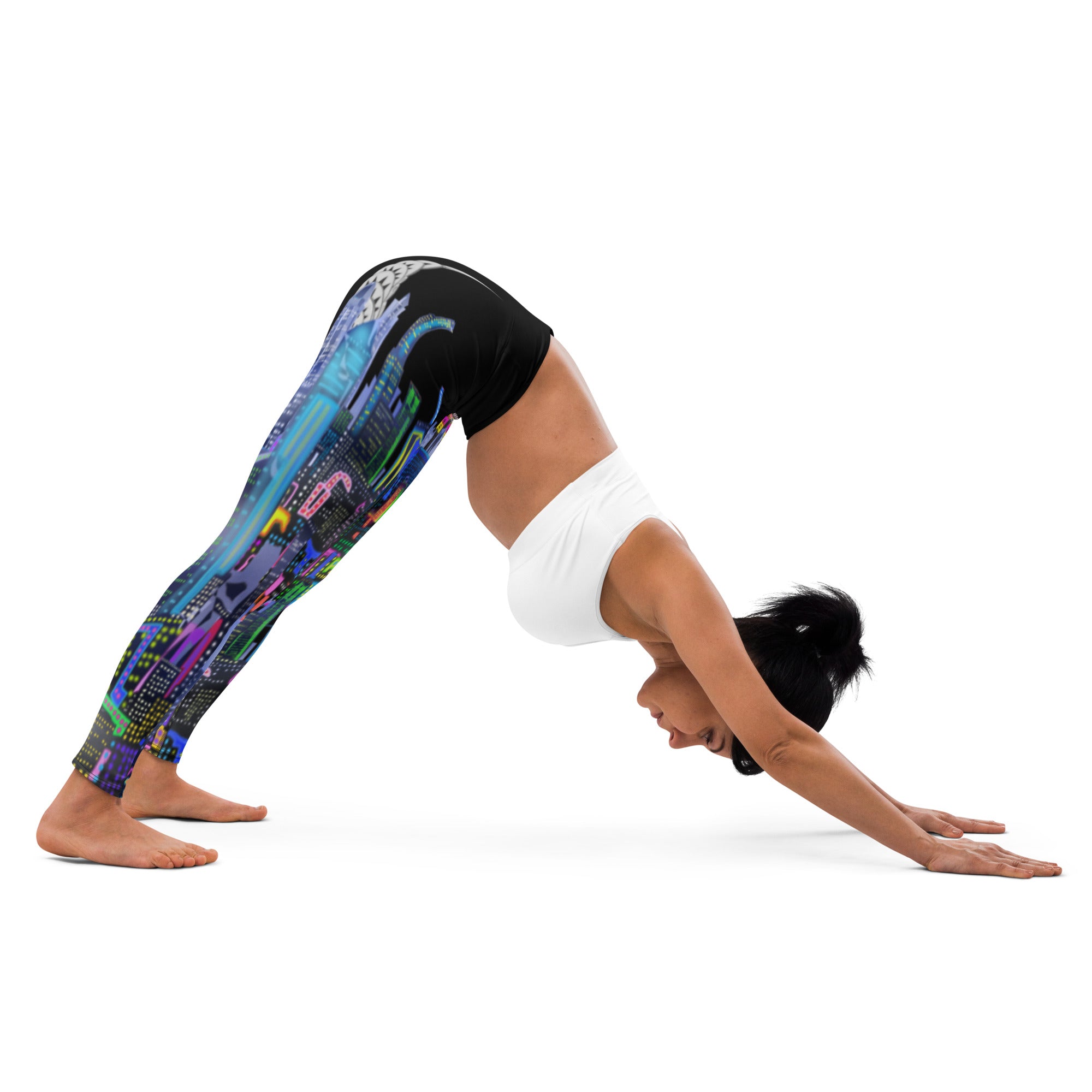 Lady wearing colorful Loria NYC Art leggings and a white sports bra, bending in a yoga pose on a white background