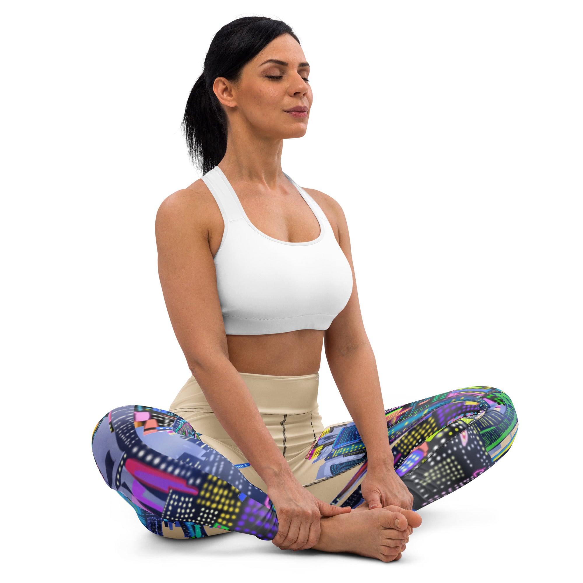 Woman in a yoga pose wearing colorful Loria NYC Art leggings and a white sports bra on a white background