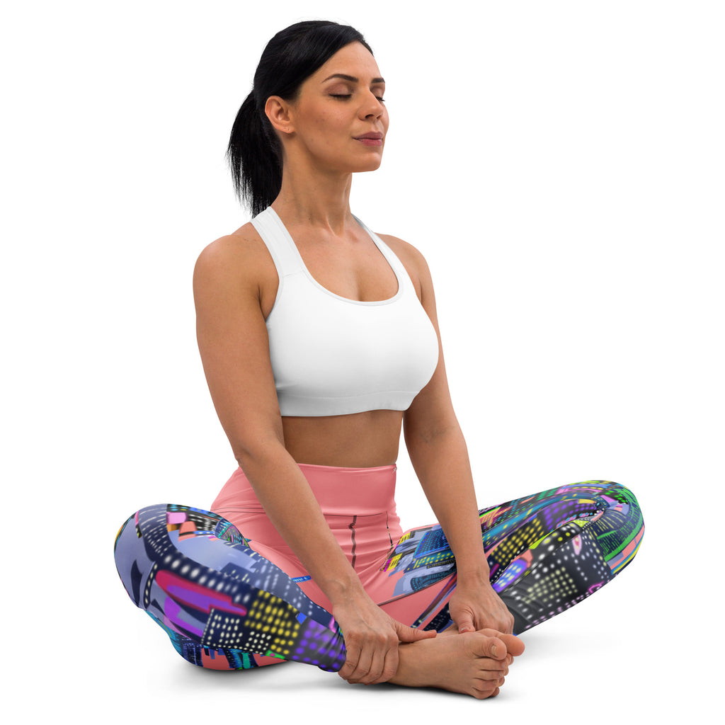 Woman sitting in a yoga pose wearing colorful Loria NYC Art leggings and a white sports bra on a white background
