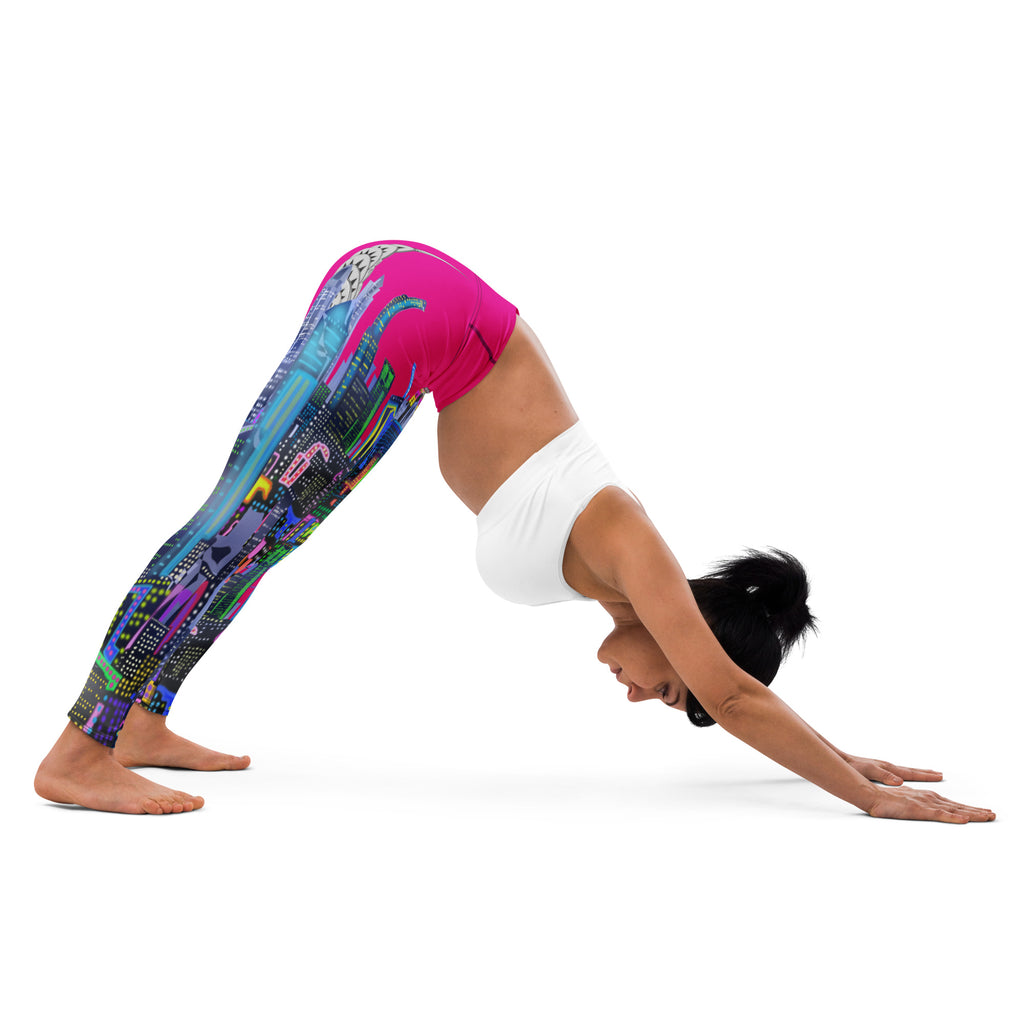 Person wearing colorful leggings with a cityscape Loria NYC Art design and white top, performing a yoga pose on a white background.