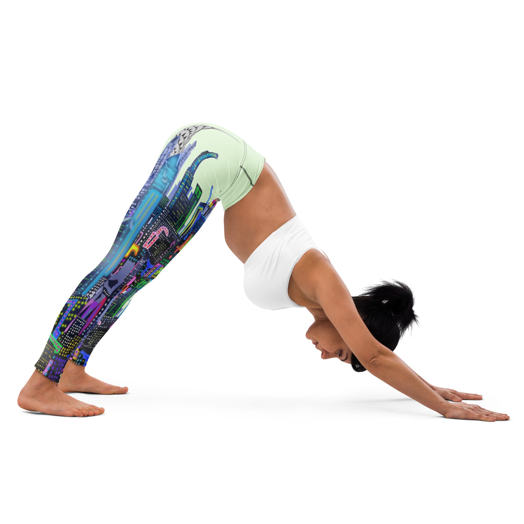 Person wearing colorful Loria NYC Art  leggings and a white top, performing a yoga pose on a white background