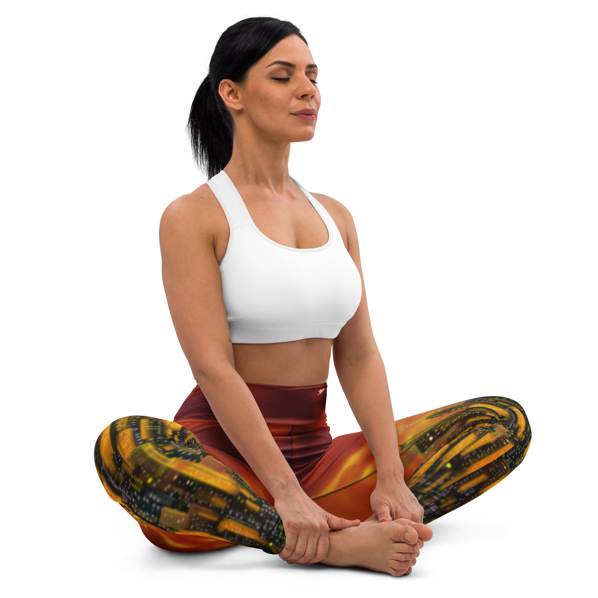 Woman in a yoga pose wearing a white sports bra and colorful Loria NYC Art pants on a white background