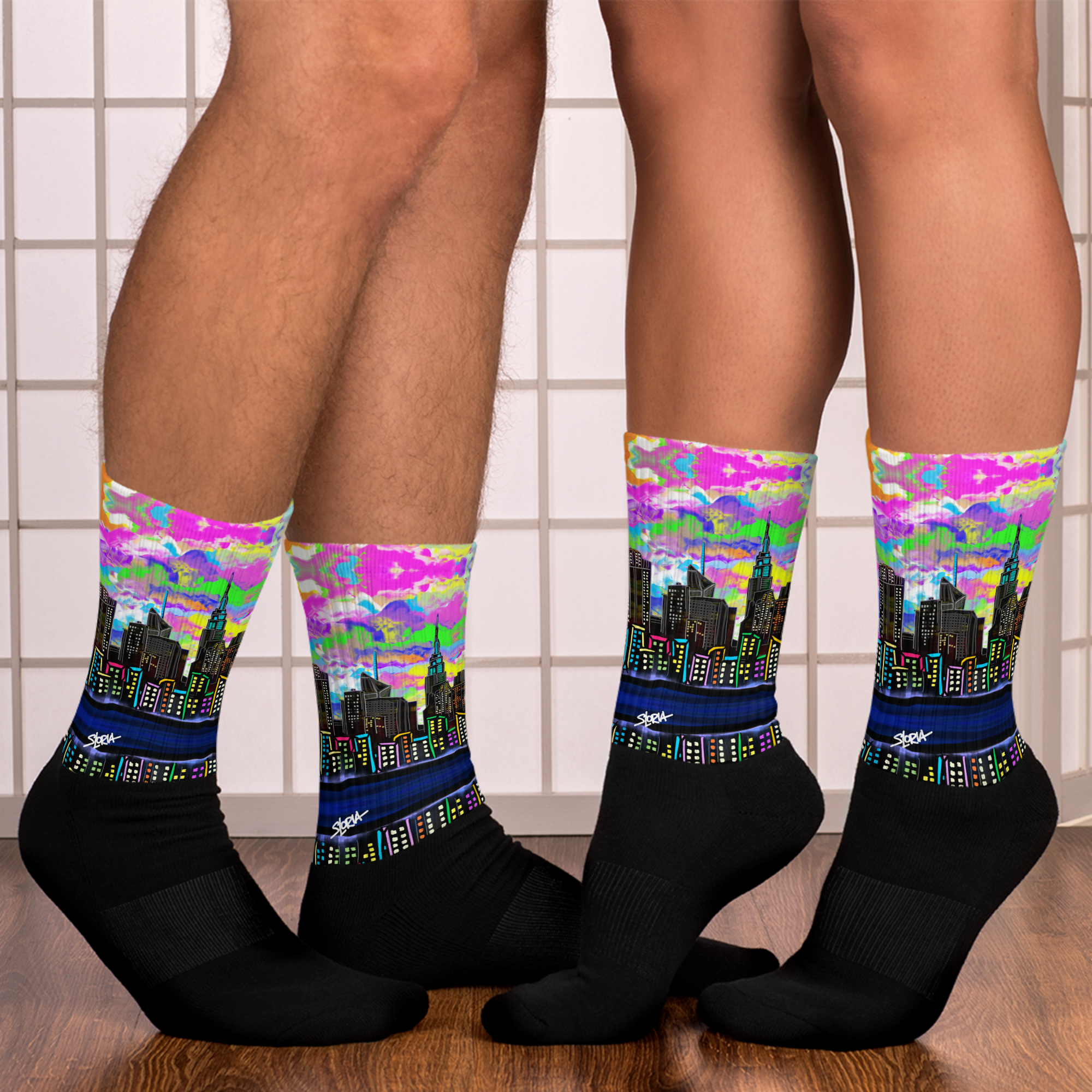 Colorful cityscape Loria NYC Art socks worn by a person on a tiled bathroom floor.