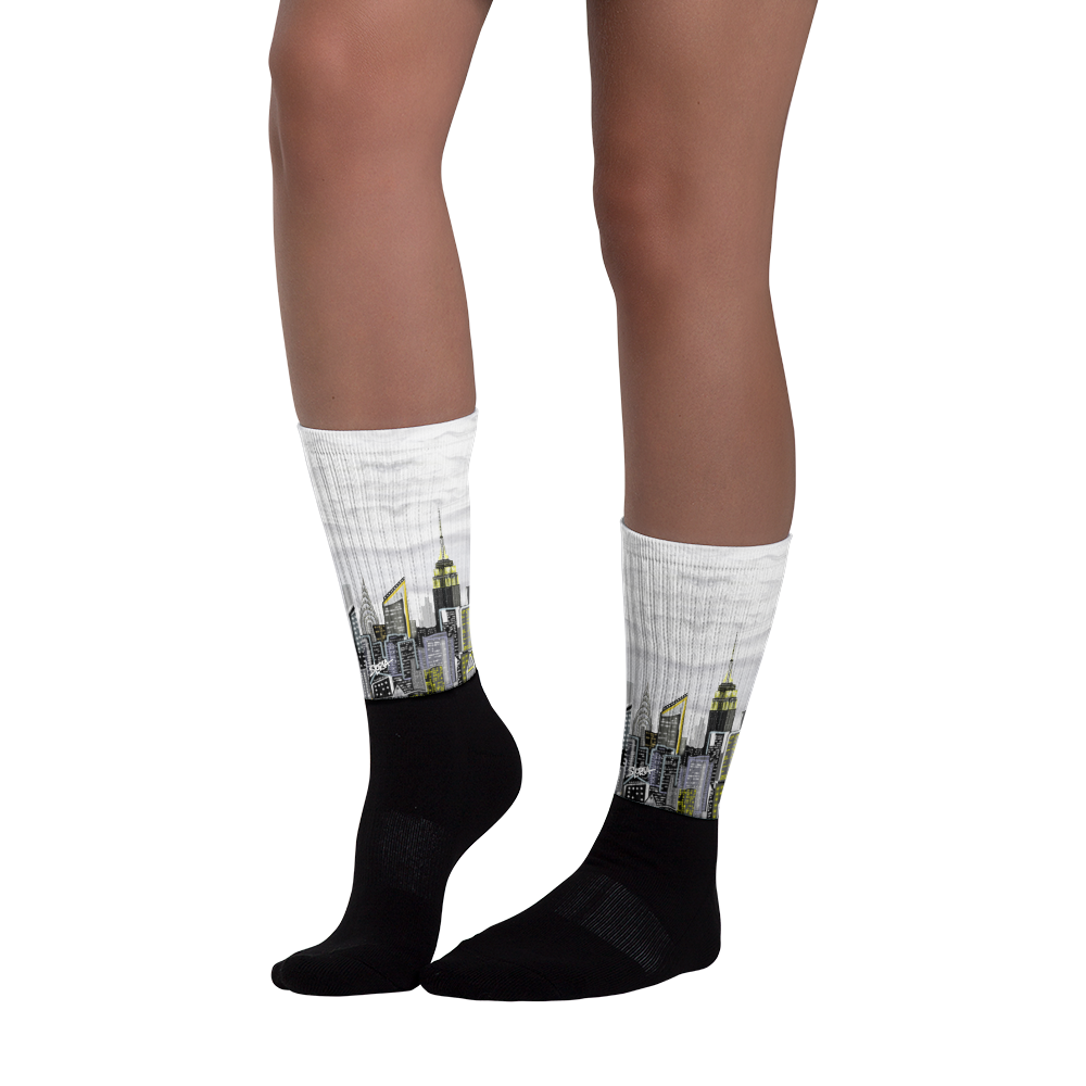 Black socks with cityscape Loria NYC Art  design worn by a person on a white background