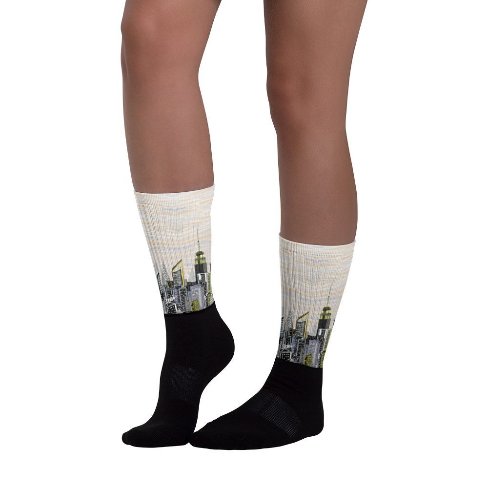 Black socks with cityscape Loria NYC Art design worn by a person on a white background