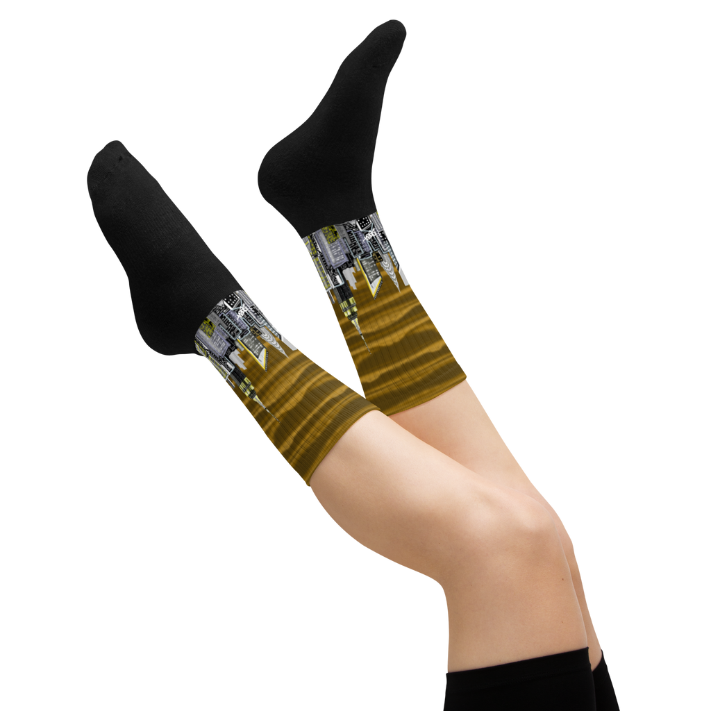 Legs wearing black Loria NYC Art socks with a unique pattern on a white background