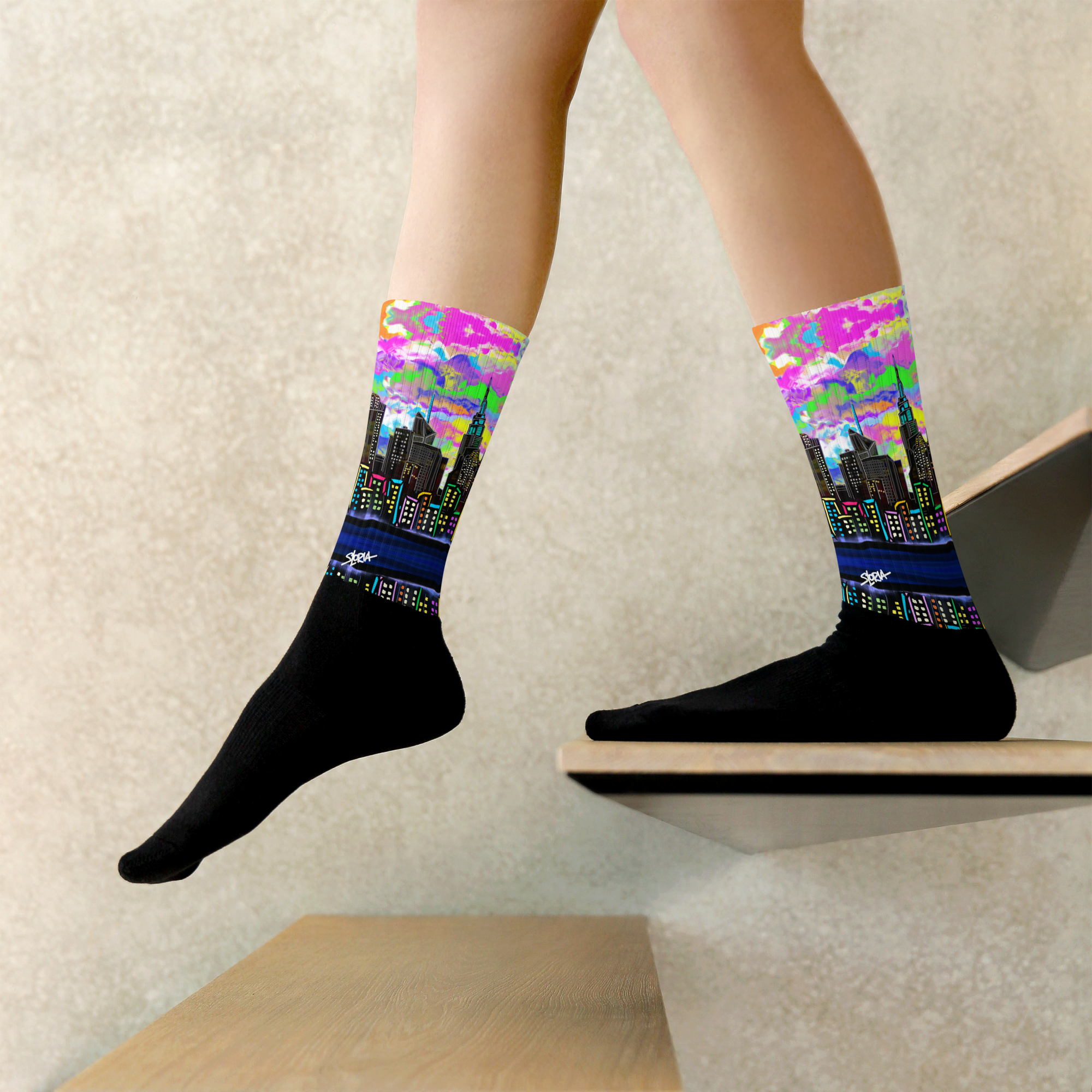 Colorful cityscape Loria NYC Art socks on a person's feet with a neutral background