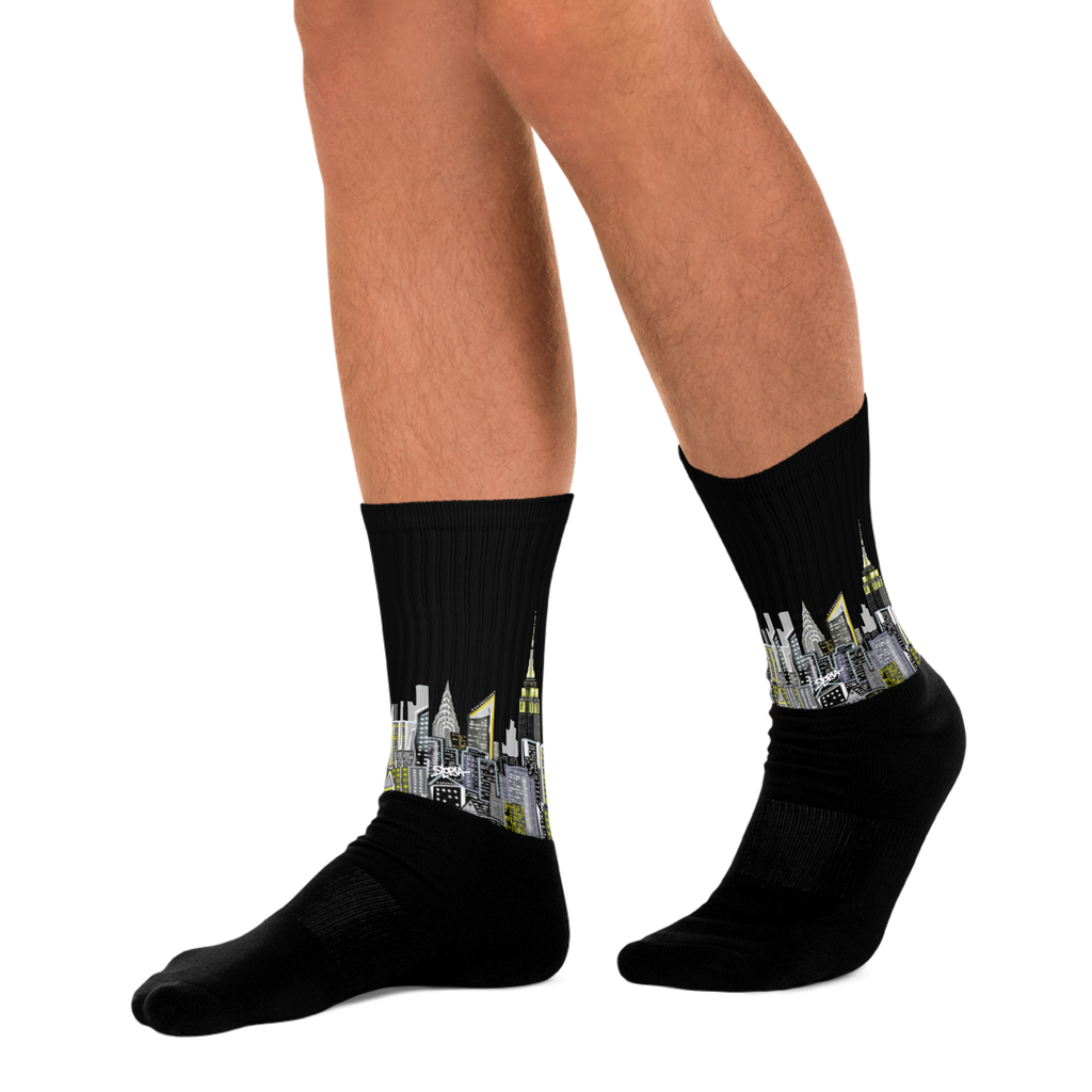 Black socks with cityscape Loria NYC Art design worn by a person on a white background