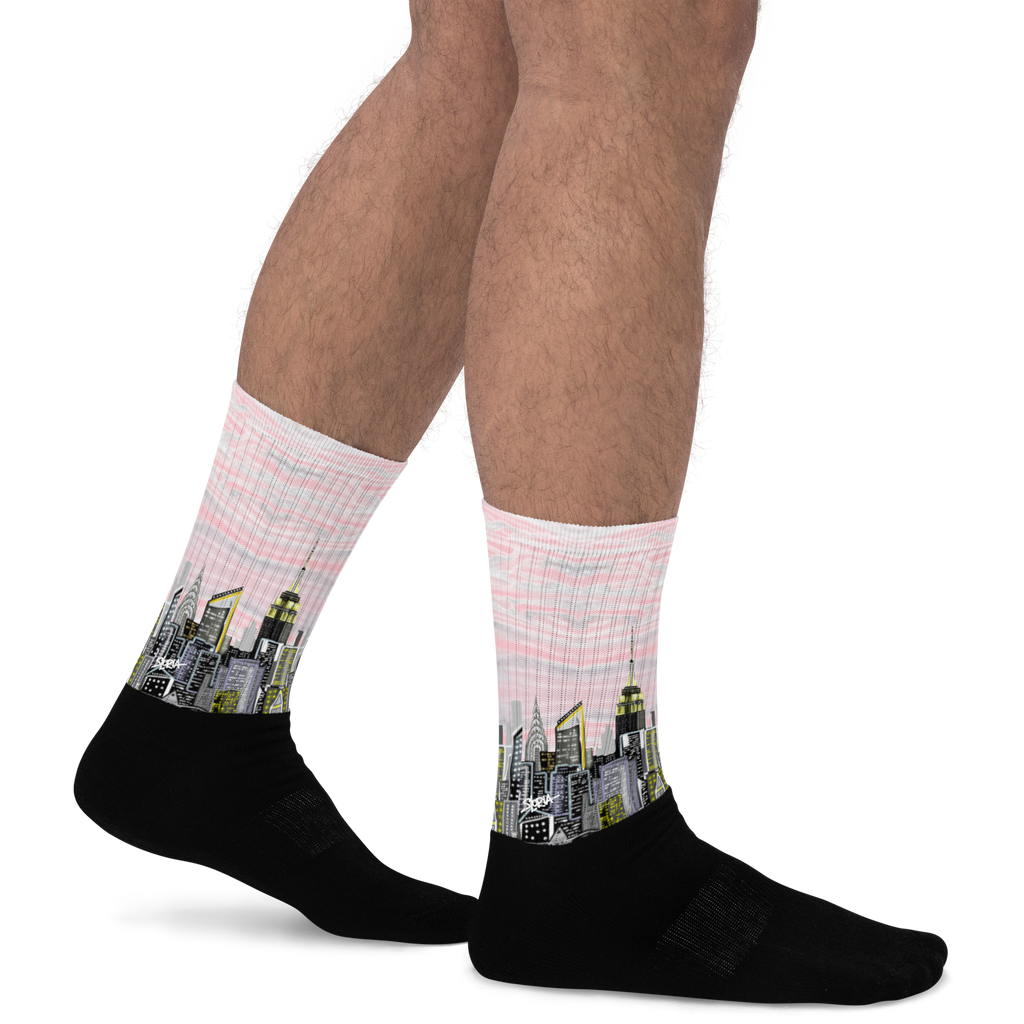 Person wearing Loria NYC Art socks with cityscape design on a white background