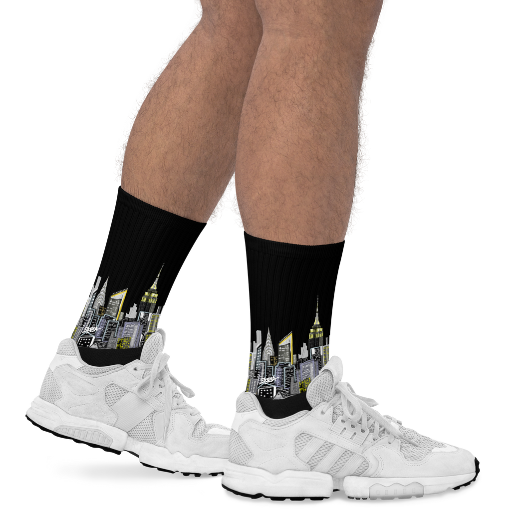 Cityscape Loria NYC Art socks worn with white sneakers on a white background