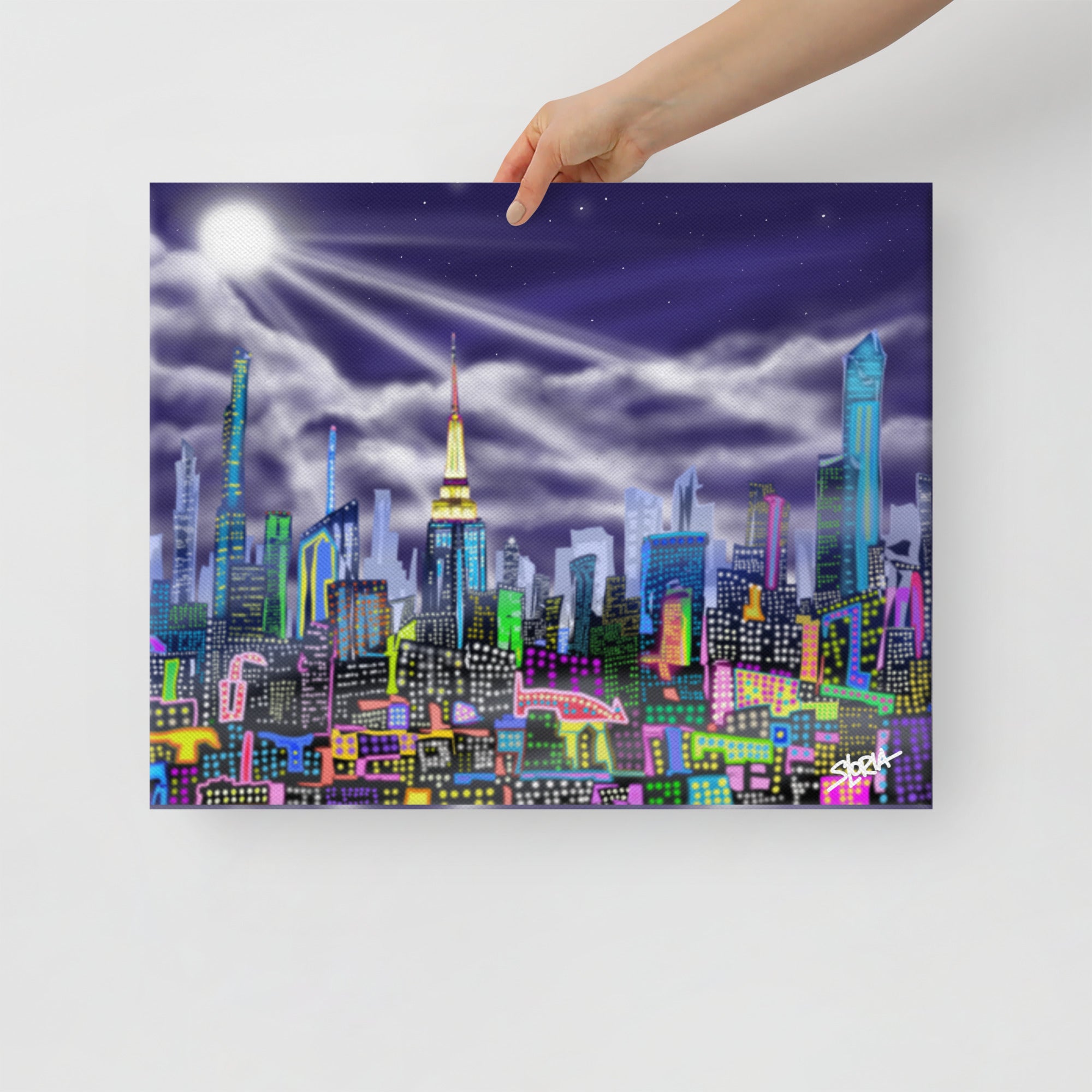 Colorful cityscape painting held by a hand against a white background,designed on a canvas print with a brand logo S.Loria by Loria NYC Art