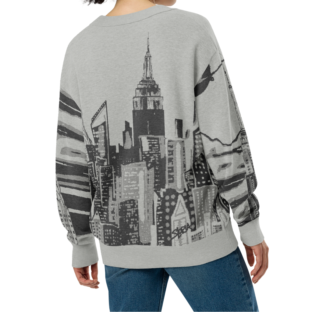 Person wearing a gray sweatshirt with a Loria NYC Art cityscape design on a white background