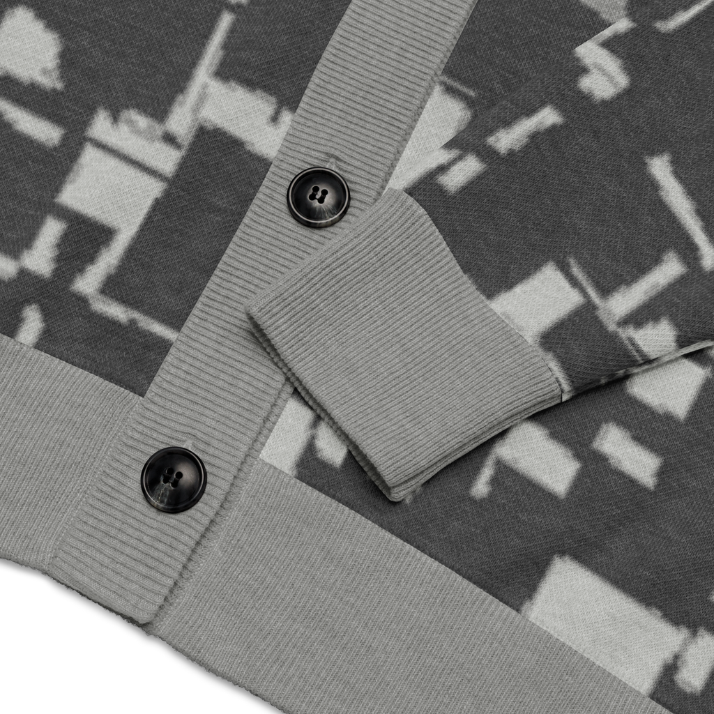 Close-up of a patterned fabric with Loria NYC Art and buttons on a white background
