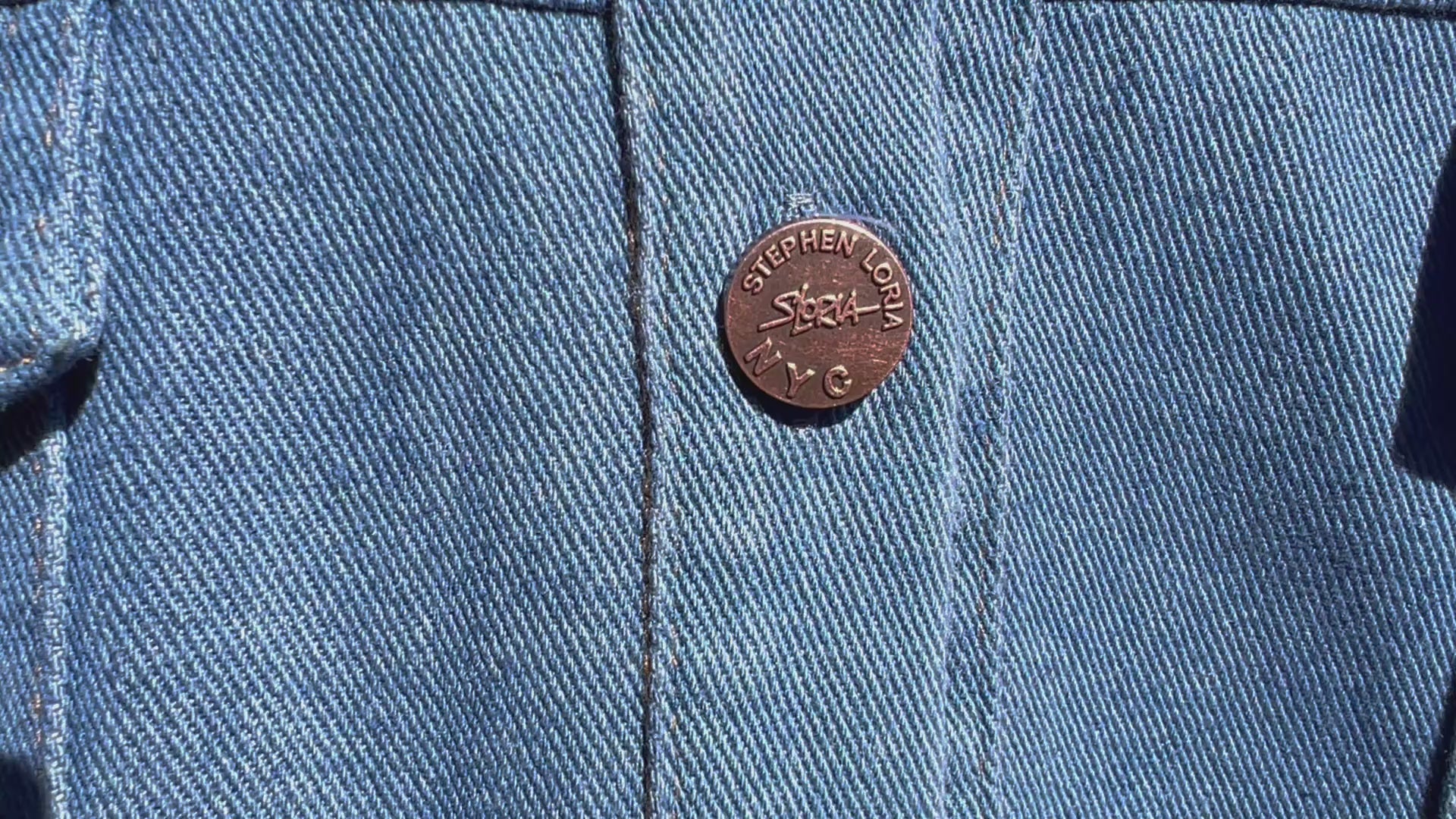 Front of a Loria NYC Art blue denim jacket