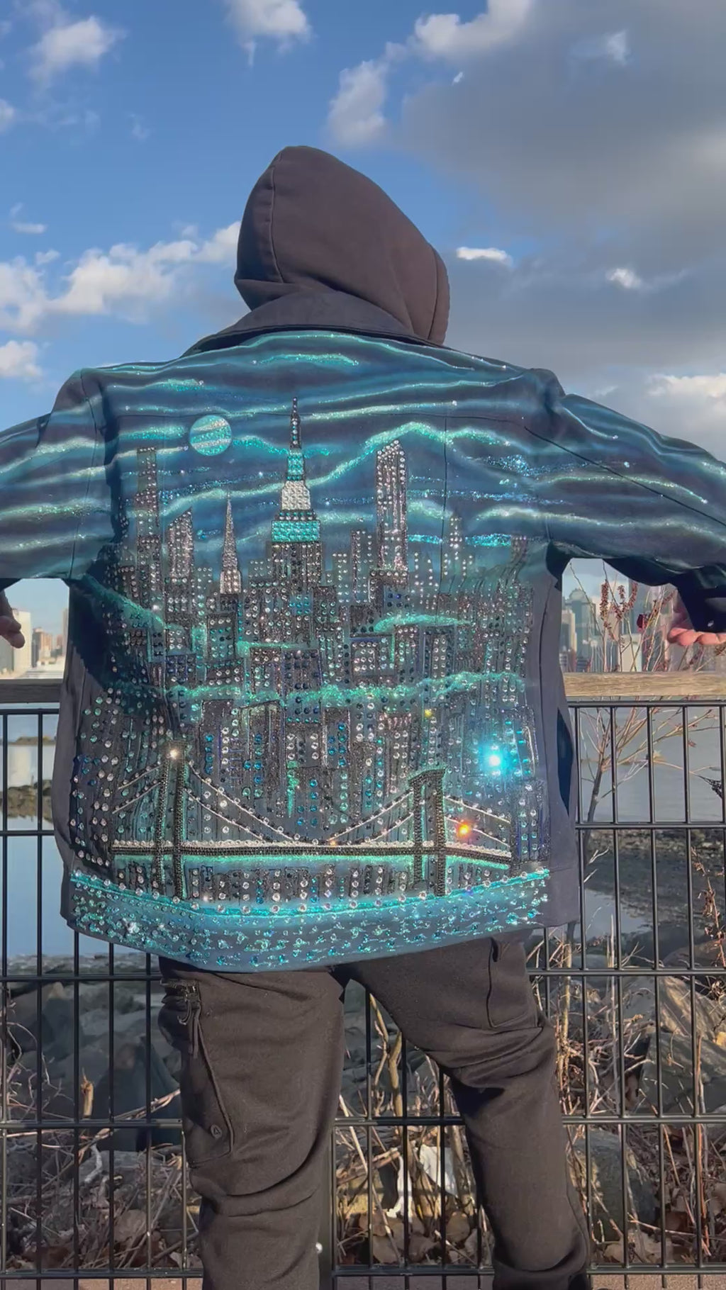 Me]an wearing a cityscape Loria NYC Art design featuring lights and glittery texture.