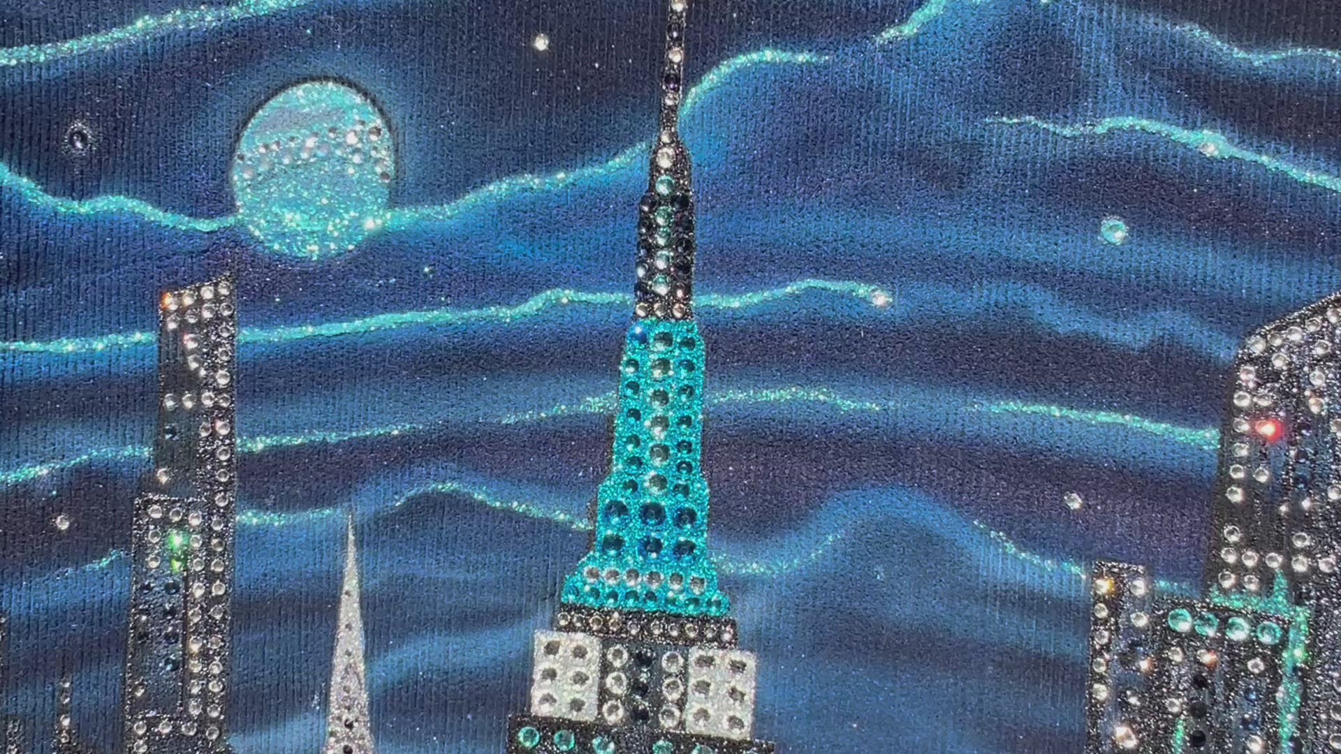 A video of a blue jacket with detailed  Loria NYC Art on the back 