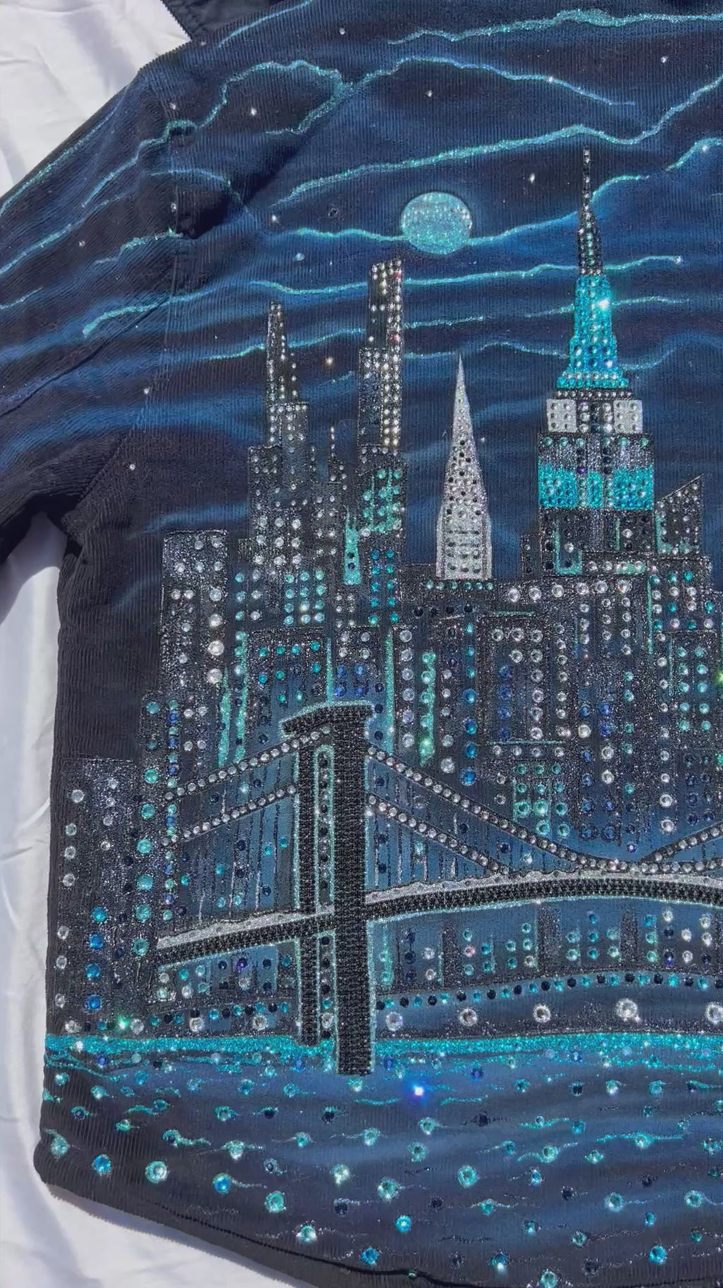 Blue jacket with Loria NYC Art on back in a video