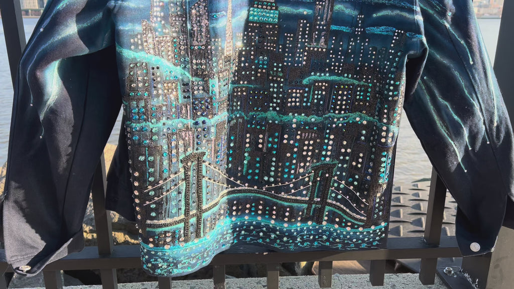 Back of detailed craft on blue denim jacket covered in Loria NYC Art with colorful skyline on a fence
