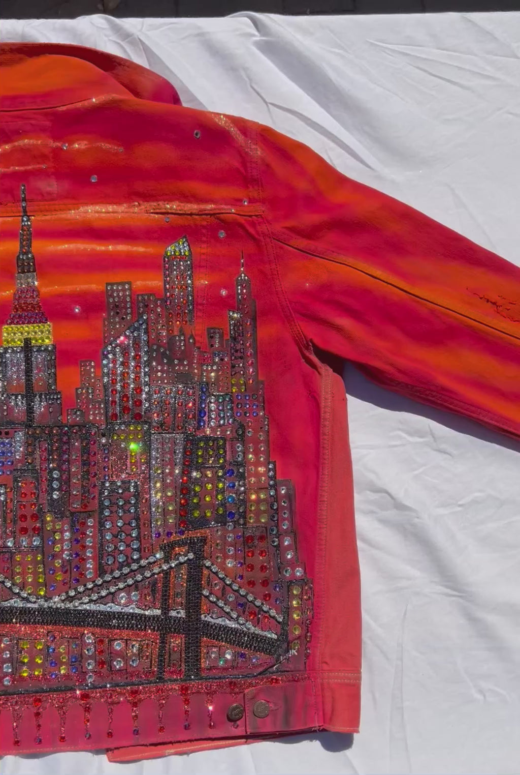 Orange Loria NYC Art jacket video with sun  reflecting on back